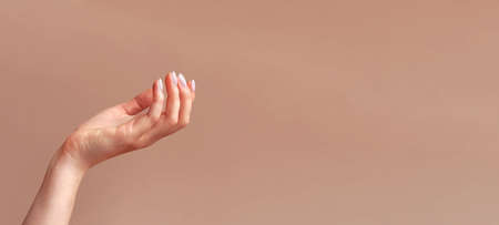 Woman's hand mockup on beige background. Minimalistic natural feminine mock-up for cosmetics, food...