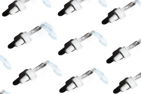 Pattern of face serum in transparent glass pipette. Natural oil, gel, cleaner. Cosmetics and healthcare concept closeup. Dose of retinol. Monkeypox, coronavirus research. Web banner for designの写真素材