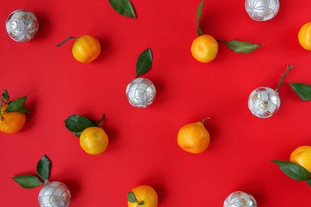 Festive silver baubles and tangerines xmas pattern on red background. Natural Christmas creative...