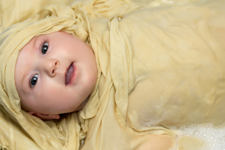 Cute baby girl is taking a herbal bath