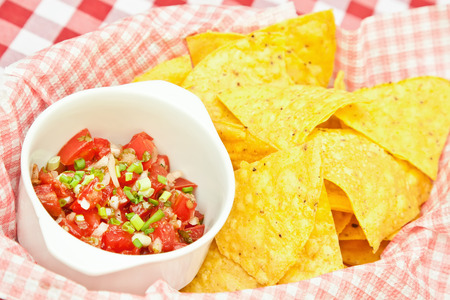 Crunchy nachos (mexican chips) with tomato salsa