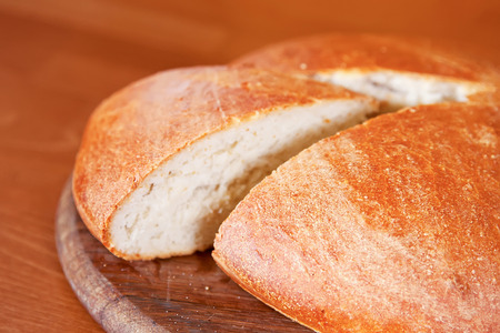 Closeup of homemade round bread on wooden board