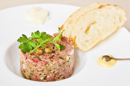 Beef tartare with parsley, capers and toasted breadの写真素材