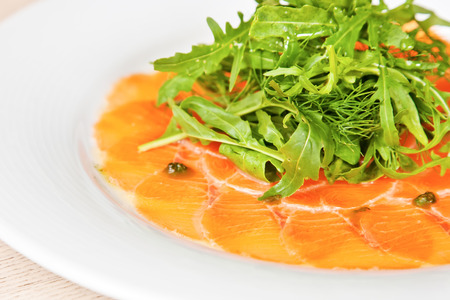 Salmon carpaccio with rucola, dill and capersの写真素材