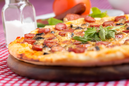 Homemade Pizza with hunter sausages, mushrooms and arugulaの写真素材