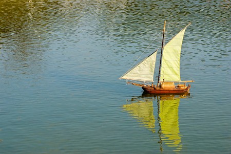 sailboat on the lake with reflection. Handmade remote control sailboat.の写真素材