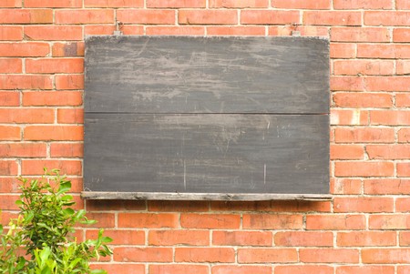 Aged blackboard on red brick wall. concept of education.の写真素材