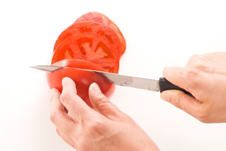 The hand hold knife and cutting the red tomato.の写真素材