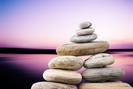 Pebbles stack in peaceful evening with smooth ocean background. Zen concept.の写真素材