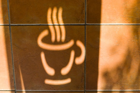 Shadow of coffee logo on the red brick floor の写真素材