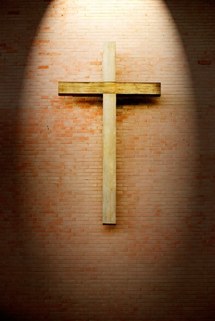 Wooden crucifix on the brick wall lighting by spotlightのeditorial素材