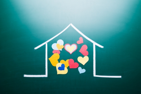 Family love concept, drawing house and colorful heart shape on blackboardの写真素材