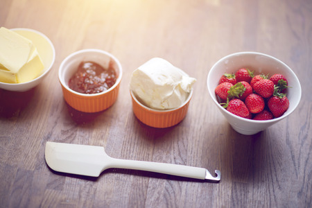 Strawberry, jelly, butter, cheese and spreader on tableの写真素材