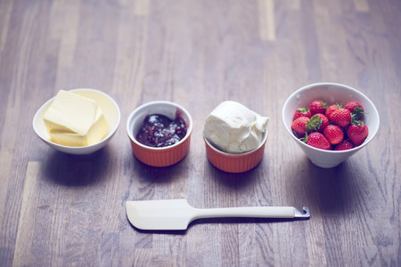 Strawberry, jelly, butter, cheese and spreader on tableの写真素材