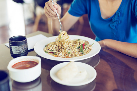 Female eating meal set of spaghetti, bread and soupの写真素材