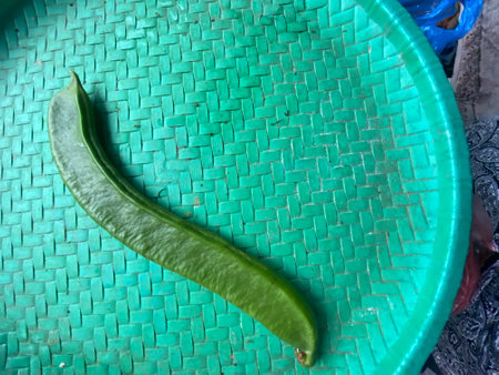 Green chili pepper on the green wicker tray. Selective focus.