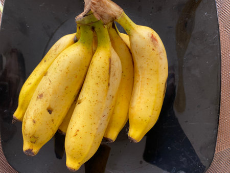 Bunch of bananas on a black plate, close-up.の写真素材