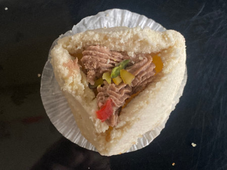 Chinese pastry with tuna and vegetables on a black background, close-up