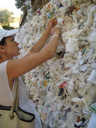The woman adheres a scarf to a memory wall to return here again.の写真素材