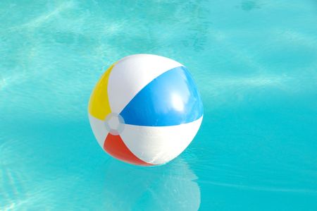 Brightly colored beach ball floating in a swimming pool