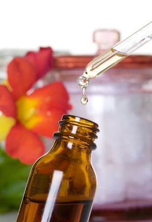 Drop falling from dropper of essential oil, aromatherapy essence, or medicinal liquidの写真素材