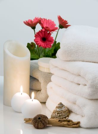 Spa scene with towels, massage cream, candles, flowers, driftwood and seashells. の写真素材