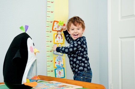 Little boy age 3 laughing and playing in his roomの写真素材