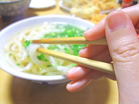 A state of trying to eat noodles using chopsticks