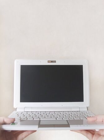 Hand holding a opened laptop
