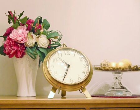 Clock and vase are on the shelf