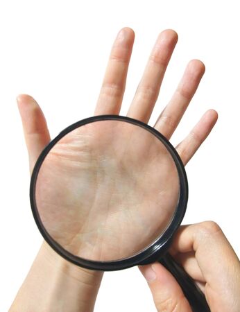 Using a magnifying glass to perform palm fortune-tellingの写真素材