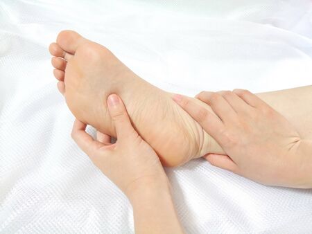 Massaging the sole of the foot with fingersの写真素材