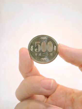 500 yen coin in handの写真素材