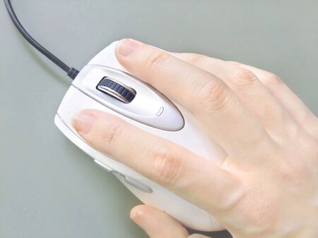 Hold the computer mouse with handの写真素材