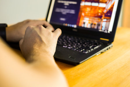 Man working on a laptop at the table. Close-up of hands.の写真素材