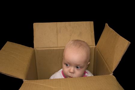 little boy sitting in a box and does not want to go 