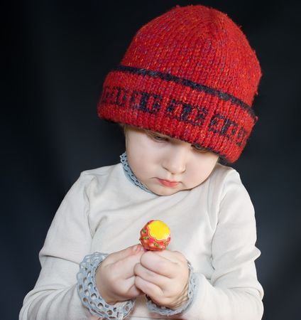 girl looks at a candy on a stickの写真素材