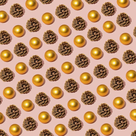 New year winter decoration layout with pinecone and bauble on pastel light pink background. Minimal Pattern.の写真素材