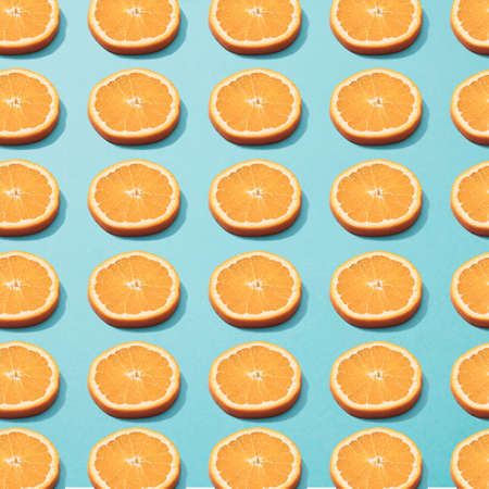 Slices of orange on blue background. Minimal pattern.の写真素材