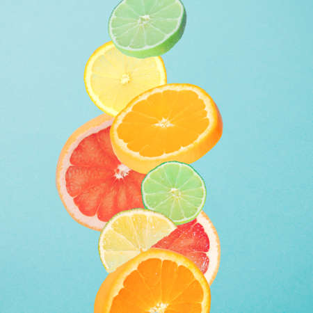 Fruit that falls. Slices of orange, grapefruit, lemon and lime. Blue background.の写真素材