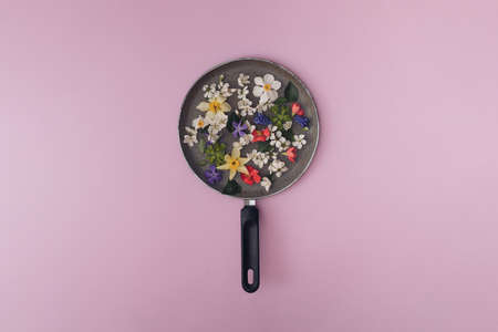Colorful flowers in a gray pan. Purple background.の写真素材