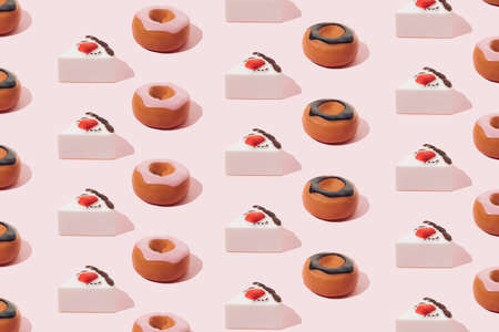 Plastic sweets. Donuts with chocolate and pink glaze and strawberry cake on a pink background.の写真素材