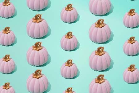 Arranged small and big pink halloween fairy tale pumpkin on seafoam mint green color background....
