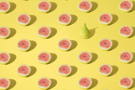 Arranged yellow fig half cutted on pastel background. Minimal design. Pattern.の写真素材