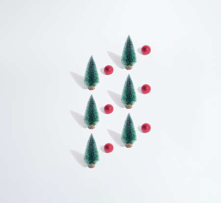 Arranged green New Year and Christmas tree with red bauble on a white pastel background. Pattern. Copy space. Minimal design and concept.の写真素材