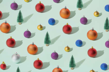 Arranged green New Year and Christmas tree with silver, yellow gold, blue, red, purple and orange bauble,  on a mint pastel background. Pattern.の写真素材