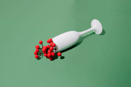 White champagne glass with Chinese cherry on green new year Christmas background.の写真素材