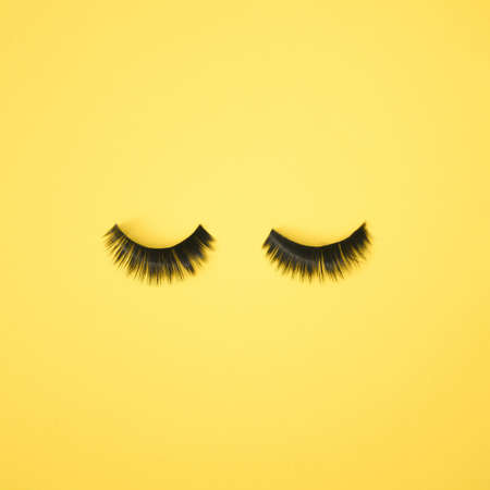 Two lashes on a yellow background. Minimal make up design.の写真素材