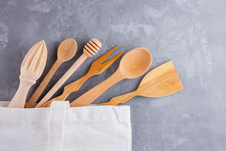 Zero waste concept. Cotton eco bag and wooden cutlery on gray background. Set of Eco friendly wooden...