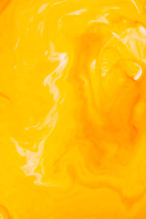 Fluid Art. Abstract blurred colorful background. Swirl liquid pattern. Marble effect of orange color. Trendy colorful backdrop. Mixing paintsの写真素材
